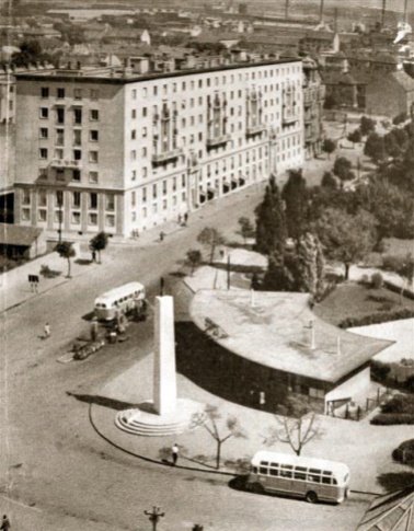 A pavilon elé az ötvenes években obeliszk épült vöröscsillaggal a tetején. Az épület a háttérben az ún. "hatemeletes". Ugyanezen építész, Lakatos Kálmán 1950 körüli alkotása. Elég nagy a váltás... (Fotó: képeslap)